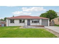 Charming bungalow with red roof, white painted brick, green lawn and ramp at 1436 S Yates St, Denver, CO 80219