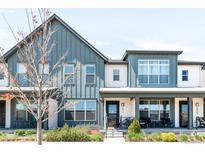 Stylish home featuring a modern design with vertical siding, large windows and a welcoming front porch at 5025 Central Park Blvd, Denver, CO 80238