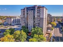 Exterior view of a multi-story condominium building with mature trees and ample parking at 2 Adams St # 901, Denver, CO 80206