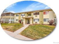 A two-story apartment complex featuring well-kept landscaping, a charming walkway, and a welcoming facade at 725 S Clinton St # 1B, Denver, CO 80247
