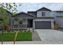 Charming two-story home with a covered porch, gray exterior, and well-manicured front yard at 1300 Loraine N Cir, Lafayette, CO 80026