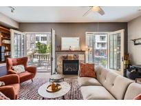 Comfortable living room with fireplace and balcony access, perfect for relaxing and enjoying the view at 1950 N Logan St # 108, Denver, CO 80203
