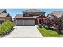 Two-story home featuring a two-car garage, concrete driveway and well maintained lawn at 172 Painted Horse Way, Erie, CO 80516