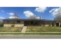 Charming single-story brick home featuring a covered front porch and well-maintained lawn at 2501 E Arkansas Ave, Denver, CO 80210
