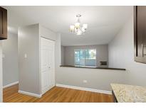 Bright dining room features a neutral color palette, wood floors, and a view into the living room at 785 S Alton Way # 10 A, Denver, CO 80247