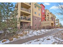Brick building exterior with balconies and snow-covered landscaping at 1144 Rockhurst Dr # 105, Highlands Ranch, CO 80129