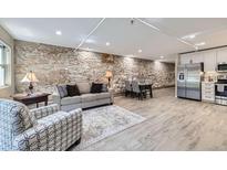 Open-concept living room featuring a stone wall, modern flooring and stainless steel appliances at 2944 Zuni St # B, Denver, CO 80211