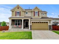 Charming two-story home featuring stone accents, a covered porch, well-kept lawn, and a two car garage at 282 Vialpando St, Brighton, CO 80601