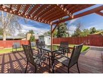 Cozy backyard patio with a dining table and chairs underneath a wooden pergola, perfect for outdoor entertaining at 7286 Wolff St, Westminster, CO 80030
