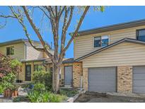 Charming townhome exterior with a well-kept lawn, a brick facade, and an attached garage at 5260 Garrison St # 11, Arvada, CO 80002