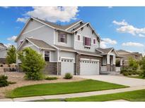 Beautiful two-story home with gray siding, stone accents, well-manicured lawn, and an attached two-car garage at 6692 S Robertsdale Way, Aurora, CO 80016