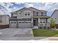 Two-story home with gray siding, three-car garage, and landscaped yard at 14499 Dahlia St, Thornton, CO 80602