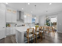 An open kitchen features quartz countertops, stainless steel appliances, and a breakfast bar with seating at 20272 Terrace View Dr, Parker, CO 80134