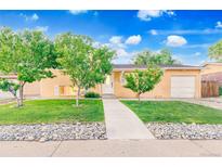 Charming ranch home featuring mature trees, a well-manicured lawn, and inviting curb appeal at 14595 Robins Dr, Denver, CO 80239