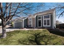 Charming home with a well-maintained lawn and inviting front entrance with tasteful, modern colors and brick accents at 19632 E Bethany Dr, Aurora, CO 80013