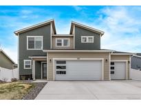 Charming two-story home showcasing modern garage doors, neutral siding, and a well-manicured lawn at 515 Bridger Ave, Fort Lupton, CO 80621