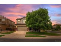 Charming two-story home with a two-car garage, mature tree, and well-manicured lawn at 10197 Quintero St, Commerce City, CO 80022