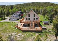 Stunning home featuring a spacious deck, mountain views, and rustic charm at 31551 Black Widow Dr, Conifer, CO 80433