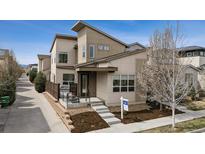 Modern home featuring a contemporary design, inviting front porch, and professional landscaping at 6631 Alan Dr, Denver, CO 80221