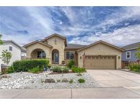 Charming stucco home with beautiful landscaping, rock features, and an attached two-car garage at 2868 Breezy Ln, Castle Rock, CO 80109