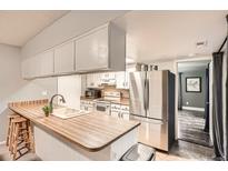 Bright kitchen features a breakfast bar, white cabinets, stainless steel appliances, and an adjacent dining area at 9483 W 89Th Cir, Broomfield, CO 80021