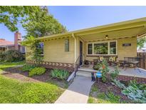 Charming brick home with well-maintained landscaping and covered front porch sitting area at 1600 Olive St, Denver, CO 80220