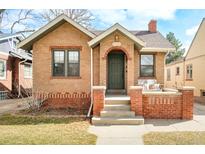 Charming brick home featuring a cozy front porch and beautiful architectural details at 4110 Decatur St, Denver, CO 80211