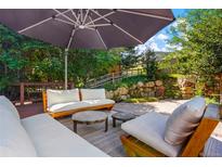 Landscaped backyard patio with lounge seating and umbrella for shade provides an outdoor living space at 469 Tripp Dr, Golden, CO 80401