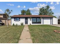 Charming single-story home featuring a well-manicured lawn, front porch and attached garage at 8641 Lowell Blvd, Westminster, CO 80031