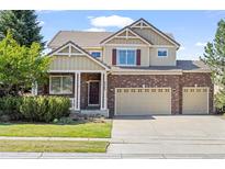 Charming two-story home with brick accents, a three-car garage, and a well-manicured lawn at 23580 E Portland Way, Aurora, CO 80016