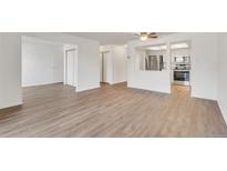 Spacious living room featuring new wood flooring and an open view to the kitchen with stainless appliances at 13992 E Marina Dr # 109, Aurora, CO 80014