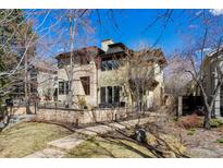 Charming two-story home with a stone accent wall, manicured lawn, and welcoming walkway at 138 Monroe St, Denver, CO 80206