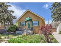 Charming single-story home featuring a quaint front porch, green shutters, and landscaped garden at 1559 Elm St, Denver, CO 80220