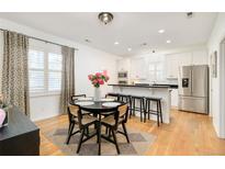 Bright kitchen and dining area with stainless steel appliances and hardwood floors at 150 S Harrison St # 106, Denver, CO 80209