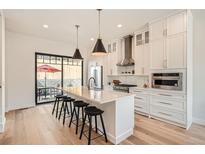 Bright kitchen features a waterfall island, stainless appliances, and easy access to the outdoor patio at 3649 W 21St Ave, Denver, CO 80211