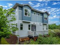 Back exterior elevation of the home showing the siding, windows and deck area at 1106 Oak Cir, Lakewood, CO 80215