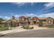 Stunning stucco home featuring a tile roof, an attached two-car garage, and a circular driveway at 3181 Firenze Pl, Highlands Ranch, CO 80126