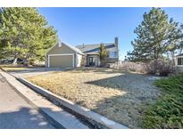Charming home with a well-manicured lawn and mature trees, set against a clear blue sky at 314 Woodstock Ln, Castle Pines, CO 80108