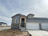 New construction home featuring stone accents, gray siding, and a two-car garage at 3398 N Duquesne Way, Aurora, CO 80019