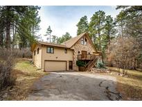 Charming home with stone accents, wood siding, attached garage, and a welcoming driveway at 530 Windmill Rd, Castle Rock, CO 80108