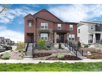 Charming townhome with brown siding, stone accents, and beautifully landscaped front yard at 9804 Rosalee Peak St, Littleton, CO 80125