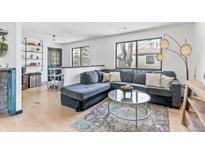 Bright living room featuring a comfortable sofa, stylish lighting, and contemporary decor at 6680 E Mississippi Ave # 3, Denver, CO 80224