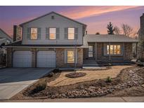 Charming two-story home with a brick and siding exterior, a two-car garage, and a well-maintained front yard at 7852 S Logan St, Littleton, CO 80122