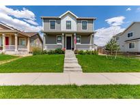 Charming two-story home with a well-manicured lawn and inviting front porch at 9862 Reunion Pkwy, Commerce City, CO 80022