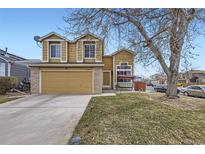 Two-story tan home featuring a two-car garage, brick accents, and a charming front porch swing at 19372 E 41St Ave, Denver, CO 80249