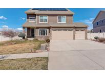 Charming two-story home with a well-maintained lawn, mature landscaping, and a three car attached garage at 4971 Ceylon Way, Denver, CO 80249