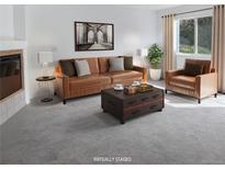 Cozy living room with leather sofa and chair, coffee table and soft natural lighting from large windows at 1339 Sumner St # B, Longmont, CO 80501