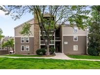 A well maintained condo building with mature trees and a grass lawn at 4896 S Dudley St # 4-7, Littleton, CO 80123