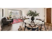 Inviting dining area with a glass table, unique chairs, and stylish decor at 1200 N Emerson St # 303, Denver, CO 80218