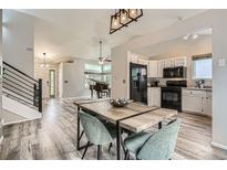Open-concept living and kitchen area boasts modern finishes and wood plank flooring at 11481 King St, Westminster, CO 80031